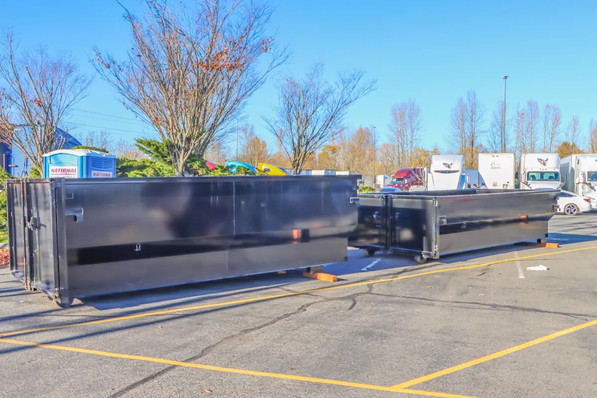 Professional dumpster rental service with roll-off container on residential driveway in West Monroe